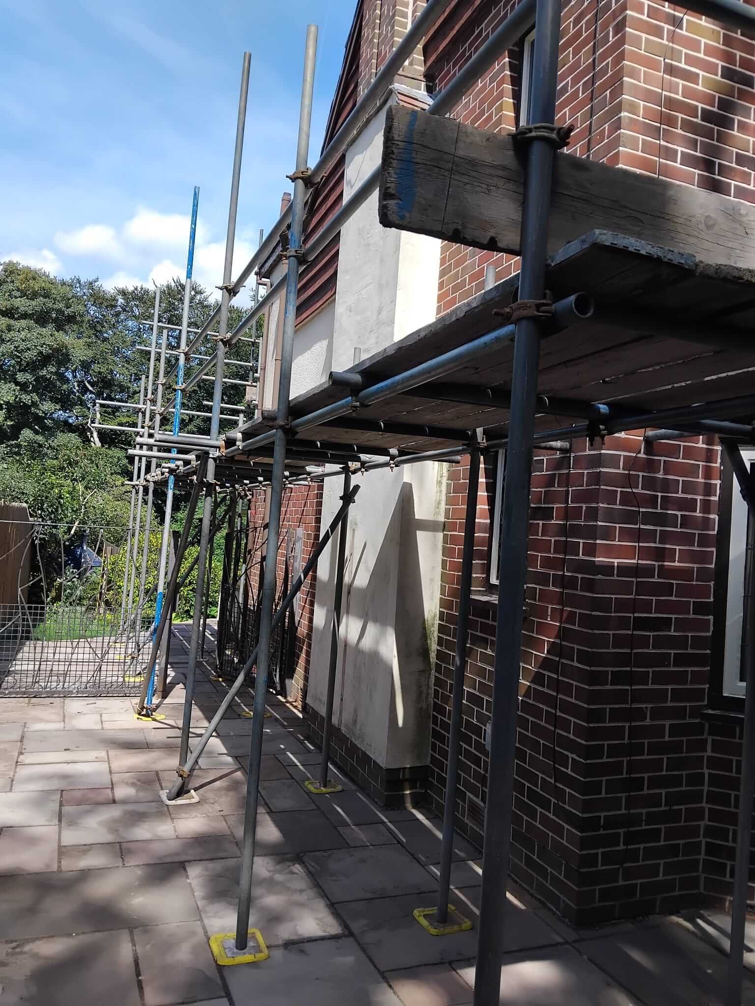 Boarded scaffold lifts running along the elevation of a Manchester property during external rendering works